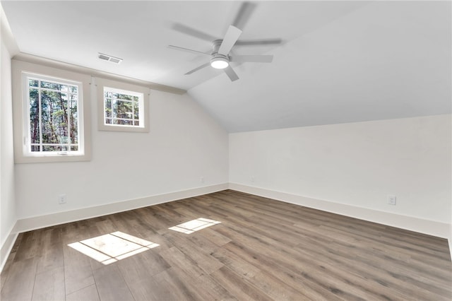 additional living space featuring visible vents, ceiling fan, baseboards, vaulted ceiling, and wood finished floors