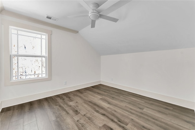 additional living space featuring visible vents, wood finished floors, baseboards, lofted ceiling, and ceiling fan