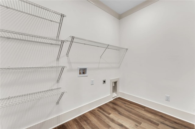 clothes washing area featuring wood finished floors, baseboards, hookup for an electric dryer, hookup for a washing machine, and laundry area