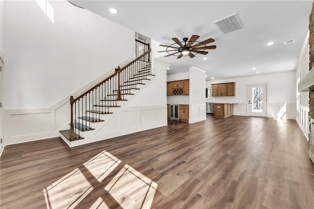 unfurnished living room featuring visible vents, a stone fireplace, stairs, and dark wood-style flooring