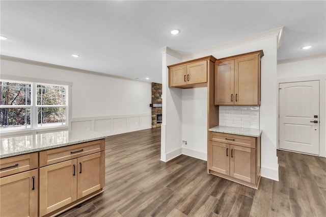 kitchen with light stone counters, dark wood-style floors, backsplash, and recessed lighting