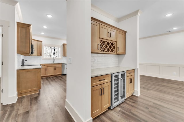 bar with wood finished floors, stainless steel appliances, a bar, wine cooler, and tasteful backsplash