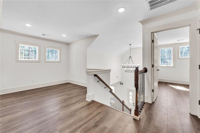 interior space featuring visible vents, baseboards, an inviting chandelier, and wood finished floors