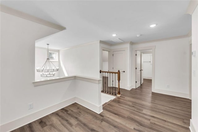 spare room with recessed lighting, a notable chandelier, wood finished floors, and baseboards