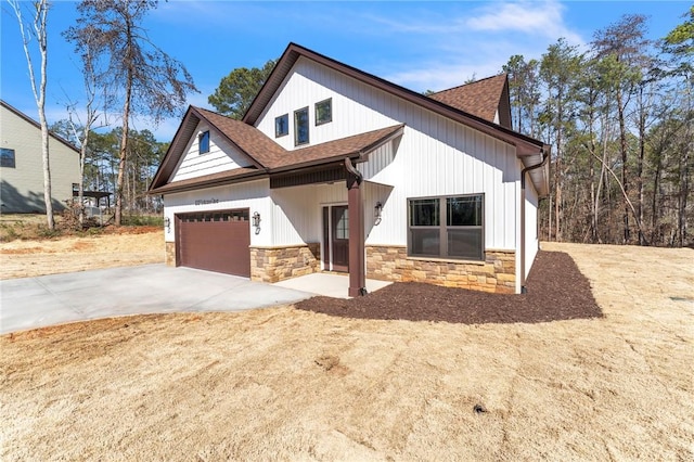 modern farmhouse featuring stone siding, driveway, a shingled roof, and a garage