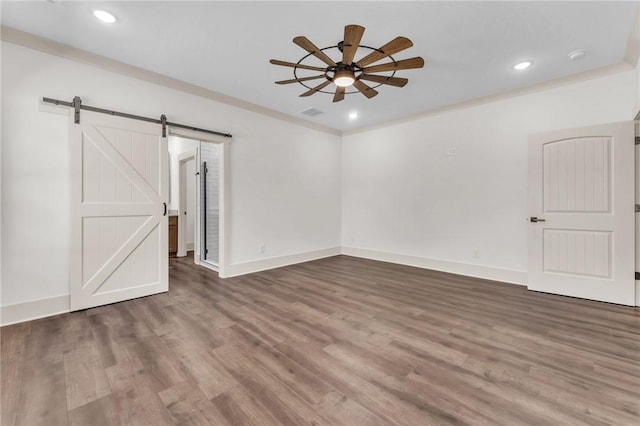 unfurnished room featuring baseboards, a barn door, recessed lighting, wood finished floors, and a ceiling fan