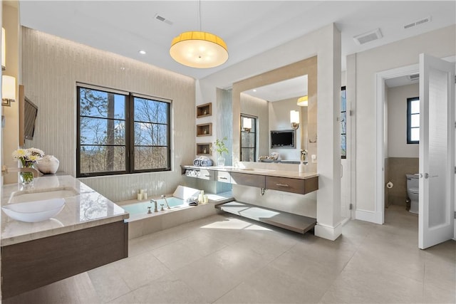 bathroom featuring a bath, visible vents, and toilet