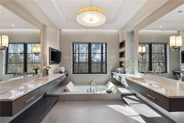 full bathroom featuring tile patterned flooring, a bath, vanity, and a tray ceiling