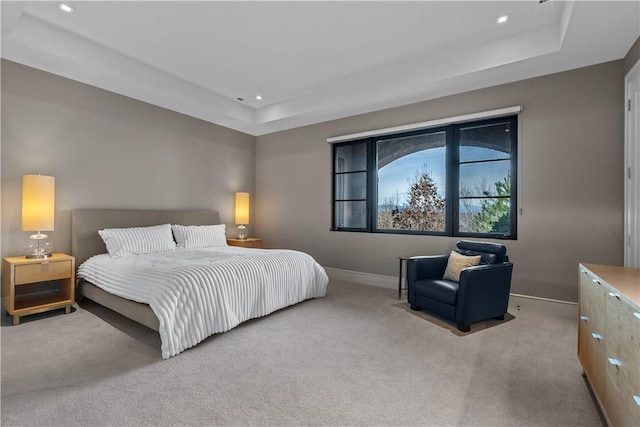 carpeted bedroom with recessed lighting, baseboards, and a raised ceiling