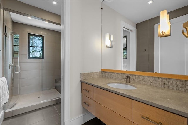 bathroom with vanity, a shower stall, tile patterned floors, and decorative backsplash