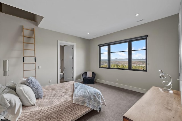 carpeted bedroom with visible vents, ensuite bath, and baseboards