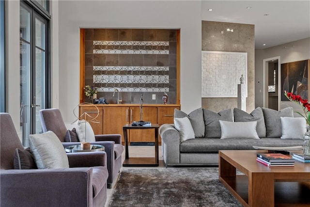 carpeted living room with a sink, indoor wet bar, and french doors