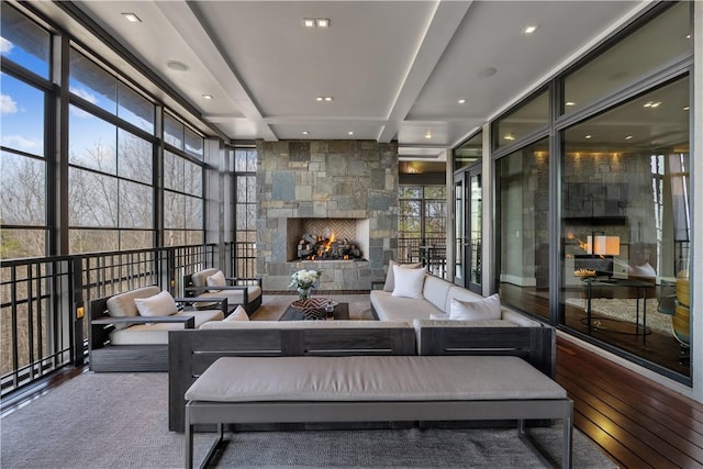 sunroom / solarium with beam ceiling and a fireplace