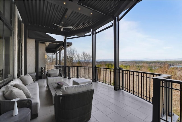 balcony featuring an outdoor living space, a mountain view, and a ceiling fan