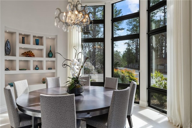 dining area featuring a notable chandelier, a high ceiling, and built in features