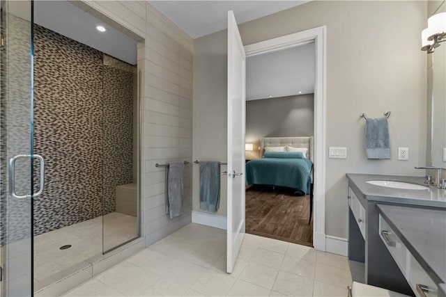 full bathroom with a shower stall, baseboards, ensuite bathroom, tile patterned floors, and vanity