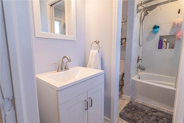 bathroom featuring toilet, vanity, and bathing tub / shower combination