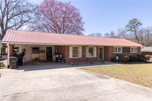 ranch-style home with brick siding, metal roof, a front lawn, and driveway