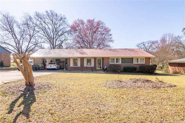 ranch-style home featuring driveway, a carport, a front yard, metal roof, and brick siding