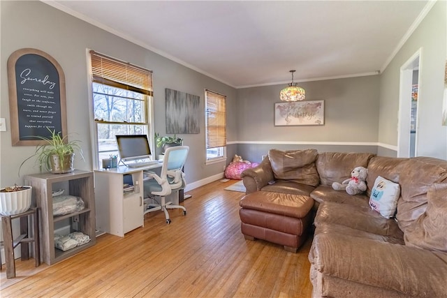 living area with baseboards, light wood-style floors, and ornamental molding