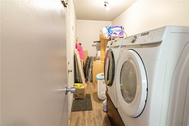 washroom featuring laundry area, washing machine and dryer, and wood finished floors