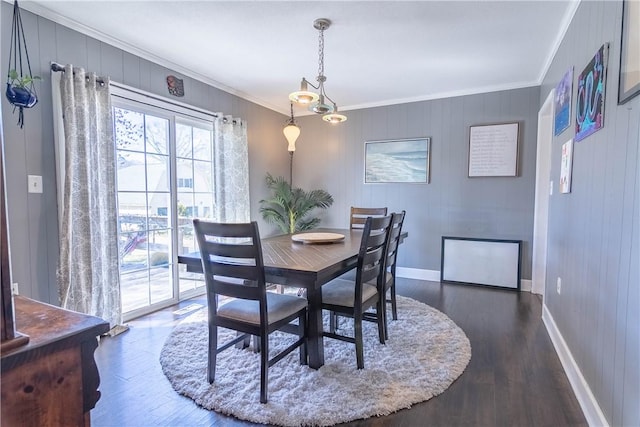 dining room with crown molding, baseboards, and wood finished floors