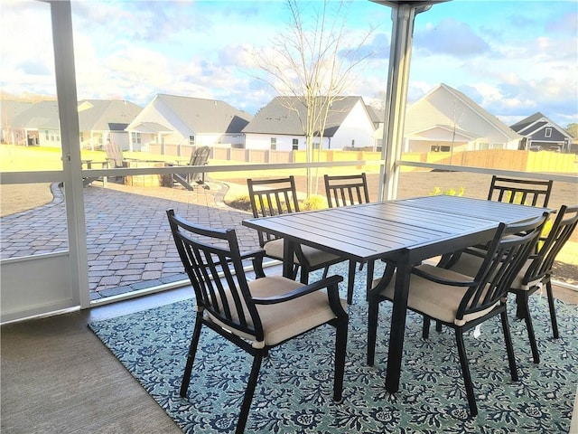 view of patio featuring outdoor dining area, fence, and a residential view