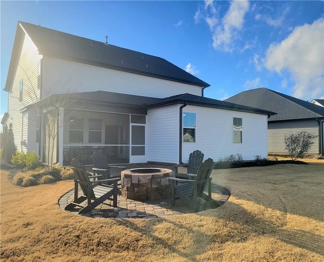 back of house featuring a sunroom, an outdoor fire pit, and a patio area