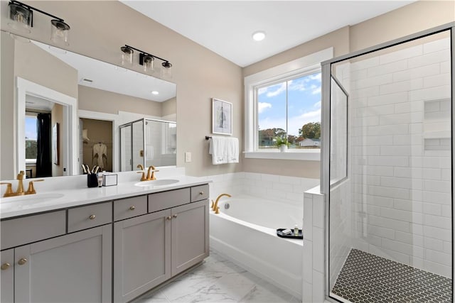 full bathroom with a shower stall, a bath, marble finish floor, and a sink