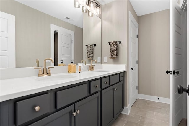 bathroom with tile patterned flooring, visible vents, double vanity, and a sink