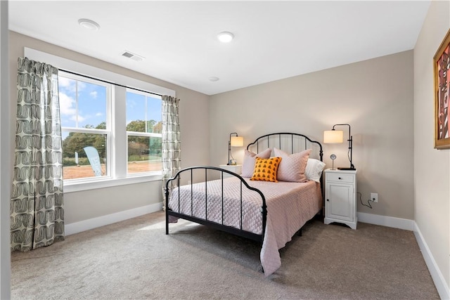 carpeted bedroom featuring baseboards and visible vents