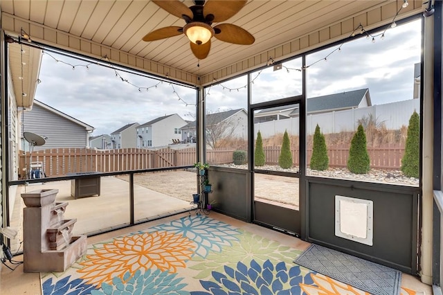 sunroom / solarium featuring wood ceiling, a residential view, and ceiling fan