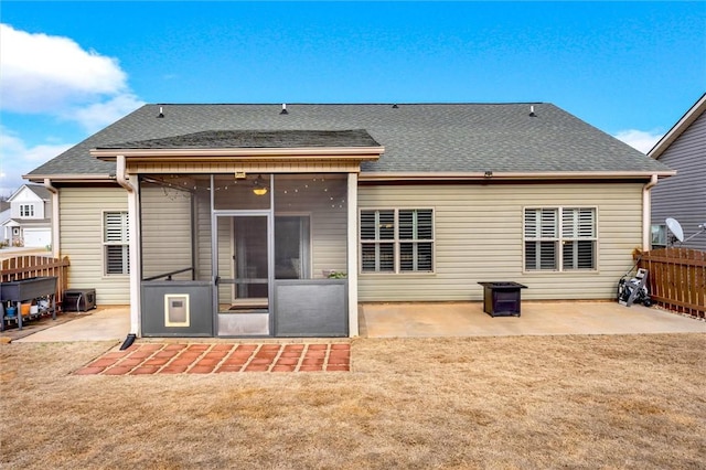 back of property featuring a yard, a patio, fence, and a sunroom