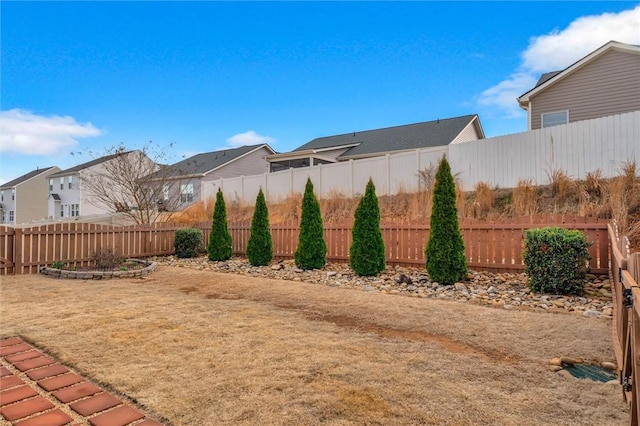 view of yard featuring a fenced backyard and a residential view