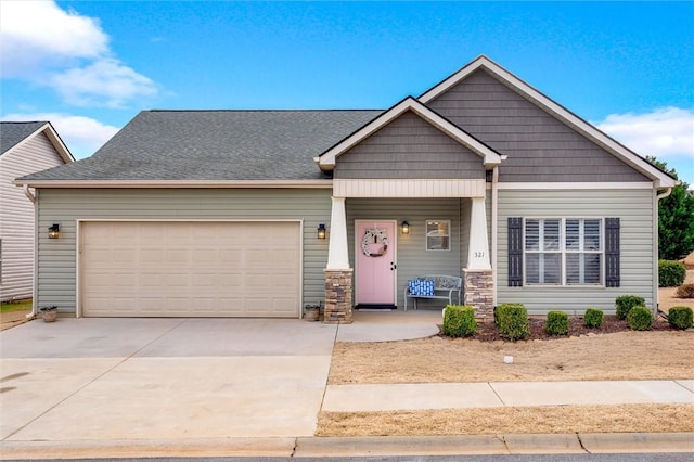 craftsman-style house with covered porch, driveway, a shingled roof, and a garage