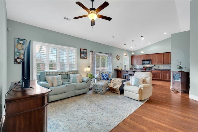 living room with a ceiling fan, wood finished floors, visible vents, high vaulted ceiling, and recessed lighting