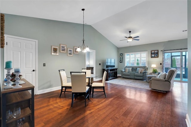 dining area with dark wood-type flooring, ceiling fan with notable chandelier, baseboards, and high vaulted ceiling