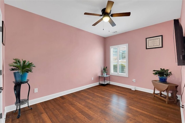 spare room featuring visible vents, wood finished floors, baseboards, and ceiling fan