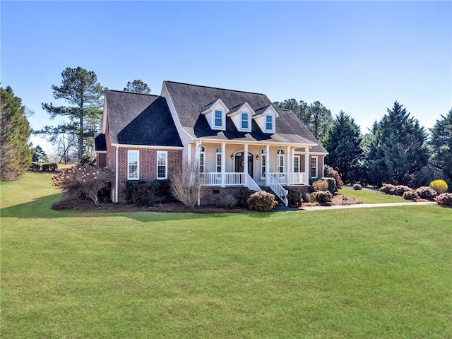 cape cod home featuring brick siding, crawl space, covered porch, and a front yard