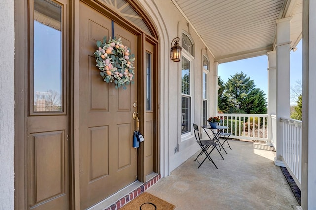 doorway to property featuring stucco siding and a porch