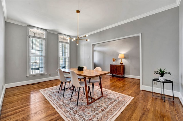 dining space with wood finished floors, baseboards, and ornamental molding