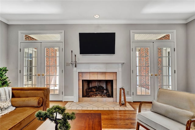 living area featuring french doors, crown molding, and wood finished floors