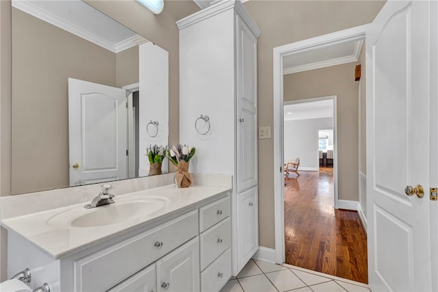 bathroom with tile patterned floors, baseboards, ornamental molding, and vanity