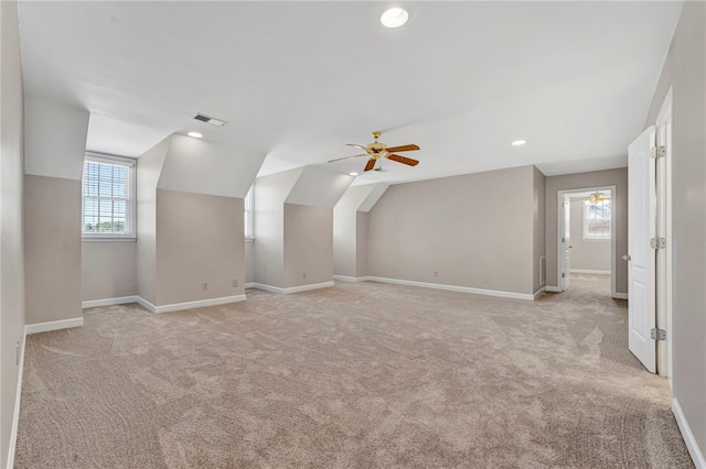 additional living space with visible vents, baseboards, light colored carpet, and lofted ceiling