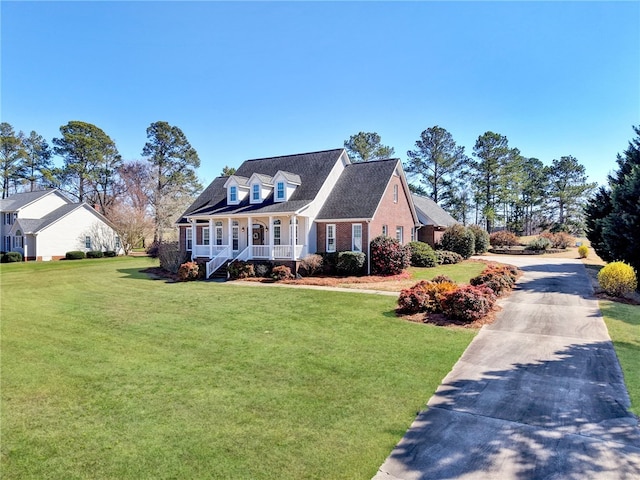 new england style home with covered porch and a front lawn