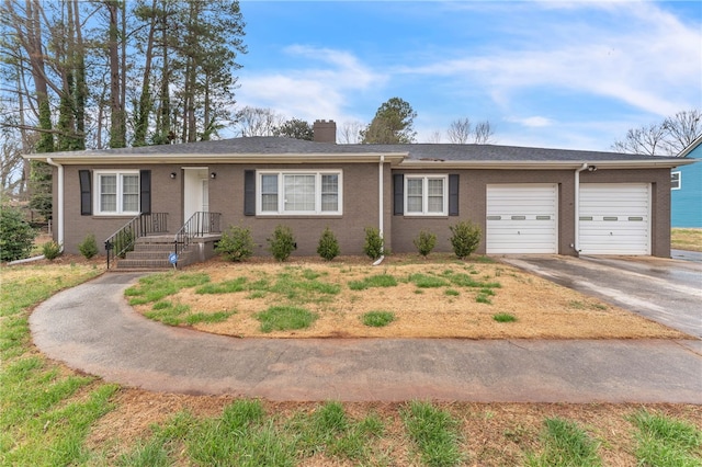 ranch-style home with brick siding, a chimney, concrete driveway, and an attached garage