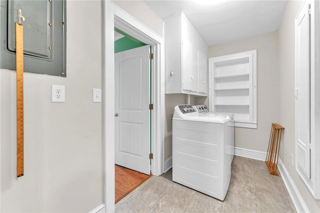 laundry room with cabinet space, electric panel, separate washer and dryer, and baseboards