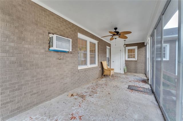 unfurnished sunroom with a ceiling fan and a wall unit AC