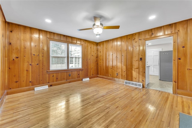 spare room featuring visible vents, ceiling fan, and light wood finished floors