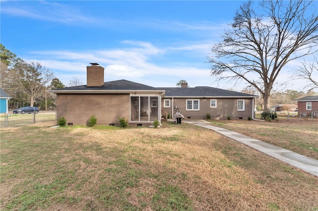 back of house with fence, a yard, a sunroom, crawl space, and brick siding